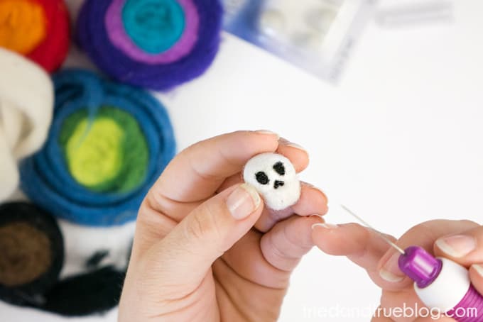 Adding black wool to white wool ball to make skeleton nose