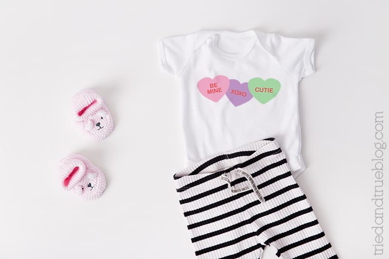 Baby onesie with Conversation Hearts on it.