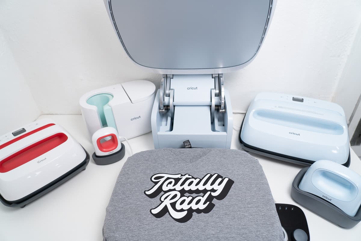 A variety of Cricut Heat Presses sitting on a table with t-shirt 