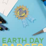 Earth Day Free Printable Badges on a blue background with markers and scissors surrounding it.