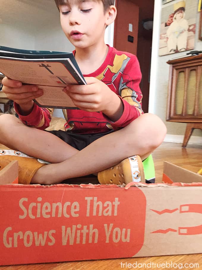 Child reading manual from the  Groovy Lab In A Box STEM subscription boxes.