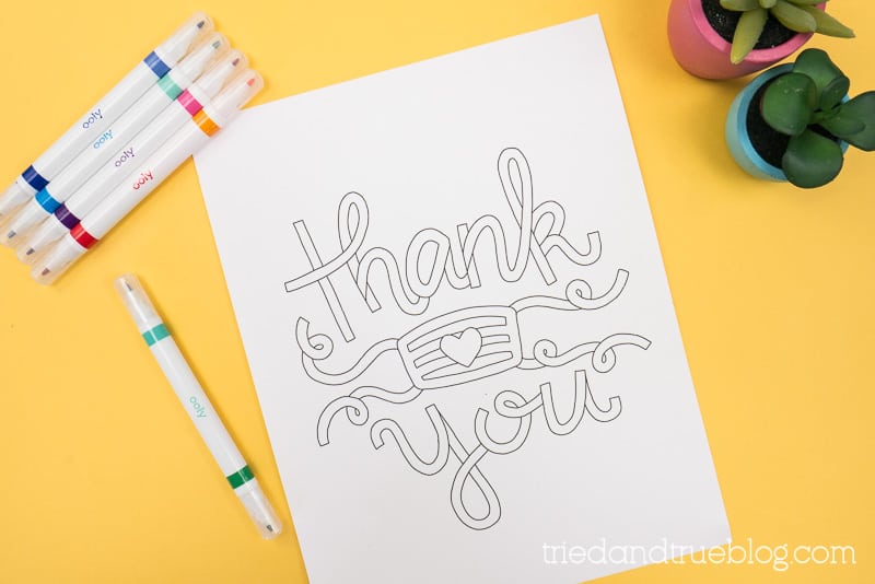 Thank You Essentials Coloring page on a yellow backdrop with markers.