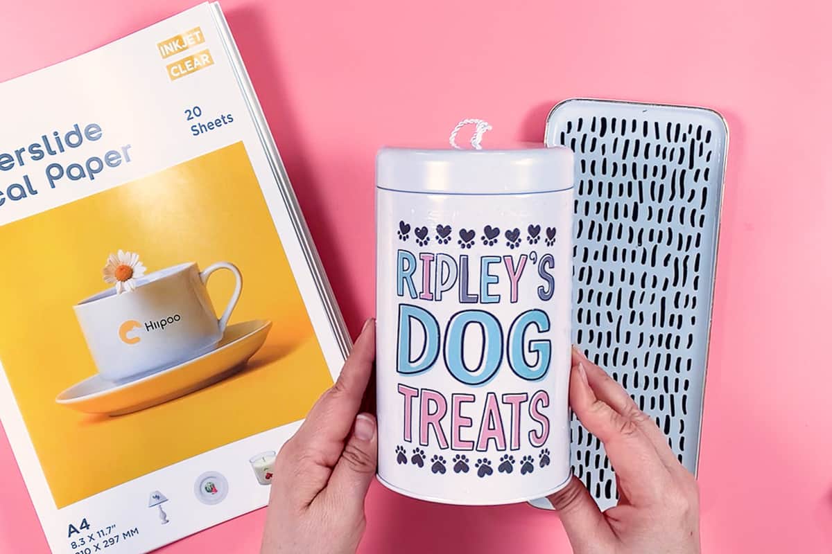 Hand holding a dog treat holder with words 