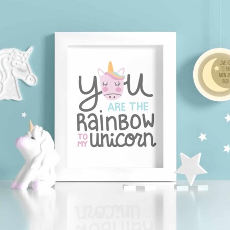 White frame with "You are the rainbow to my unicorn" art in a blue room.